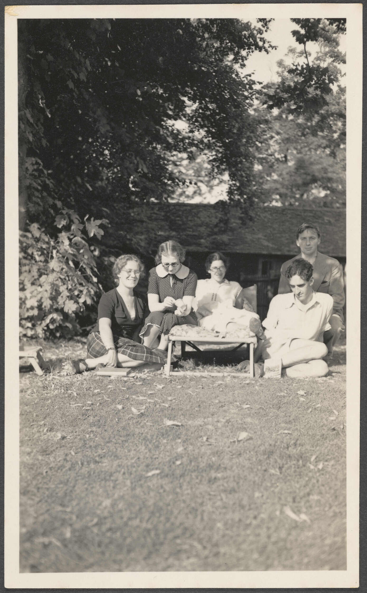 Group sitting on a lawn, including Charles Brasch