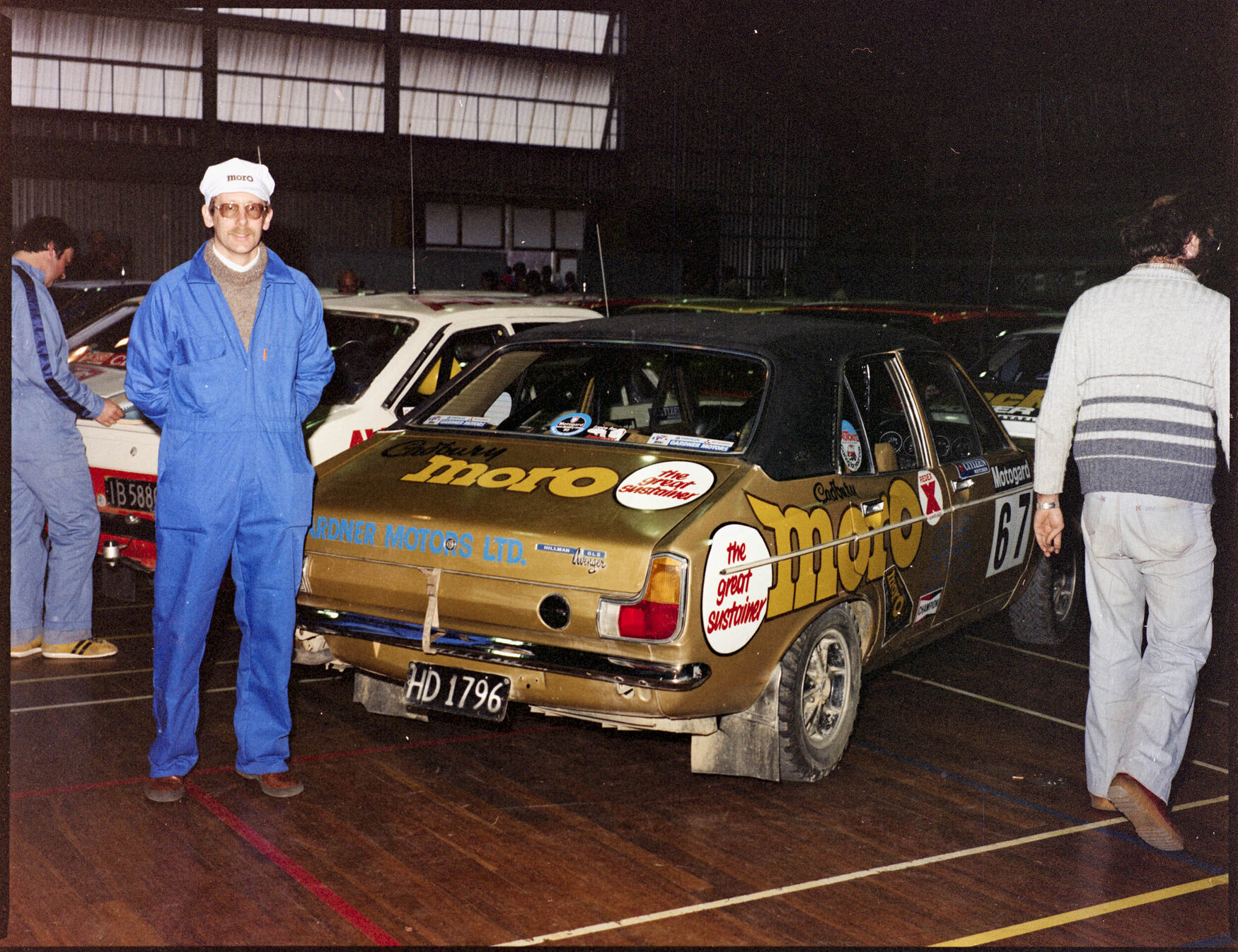 Man standing next to Hillman Avenger rally car sponsored by Cadbury Moro