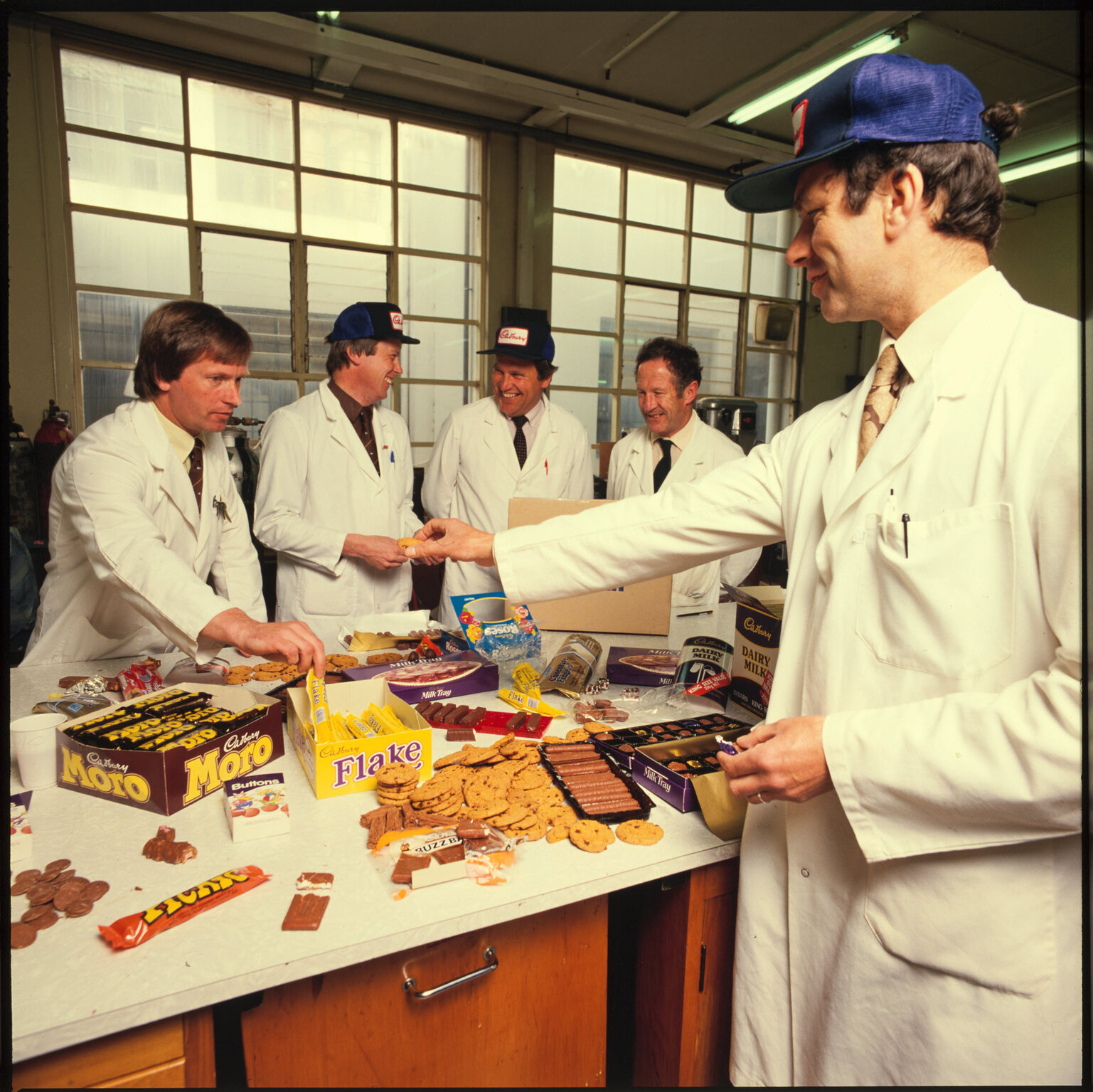 Five Cadbury staff in lab coats with arrangement of products