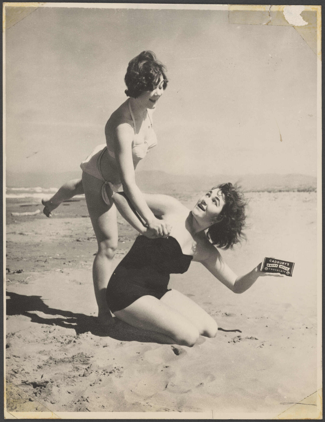 Two young women on Waimairi Beach with Cadbury Dairy Milk chocolate