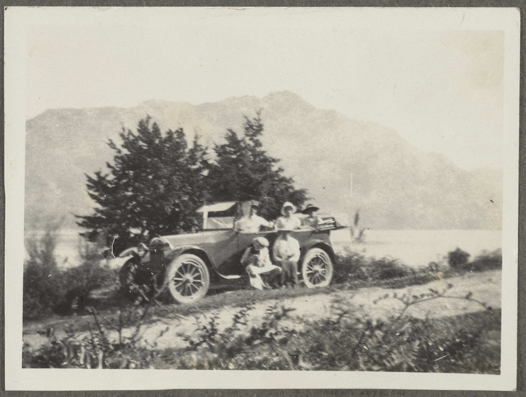 Car parked on road, with five unidentified individuals