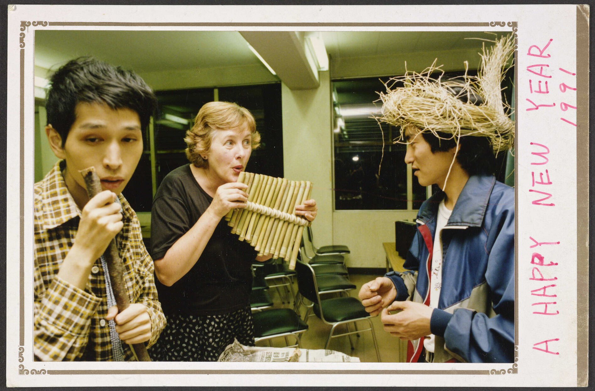 Postcard with photograph showing Elizabeth Hanan playing a bamboo flute