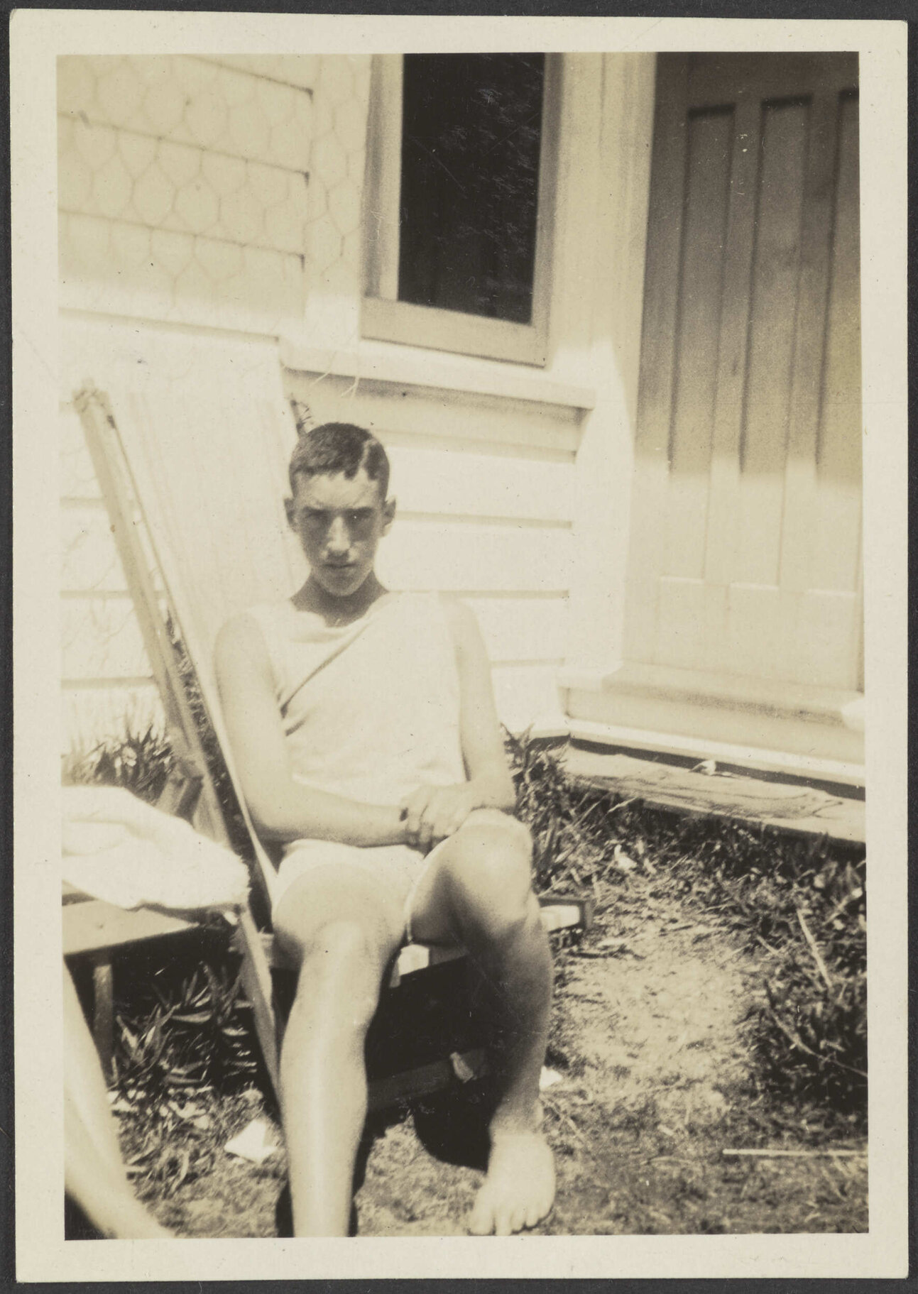 Charles Brasch outside wooden house