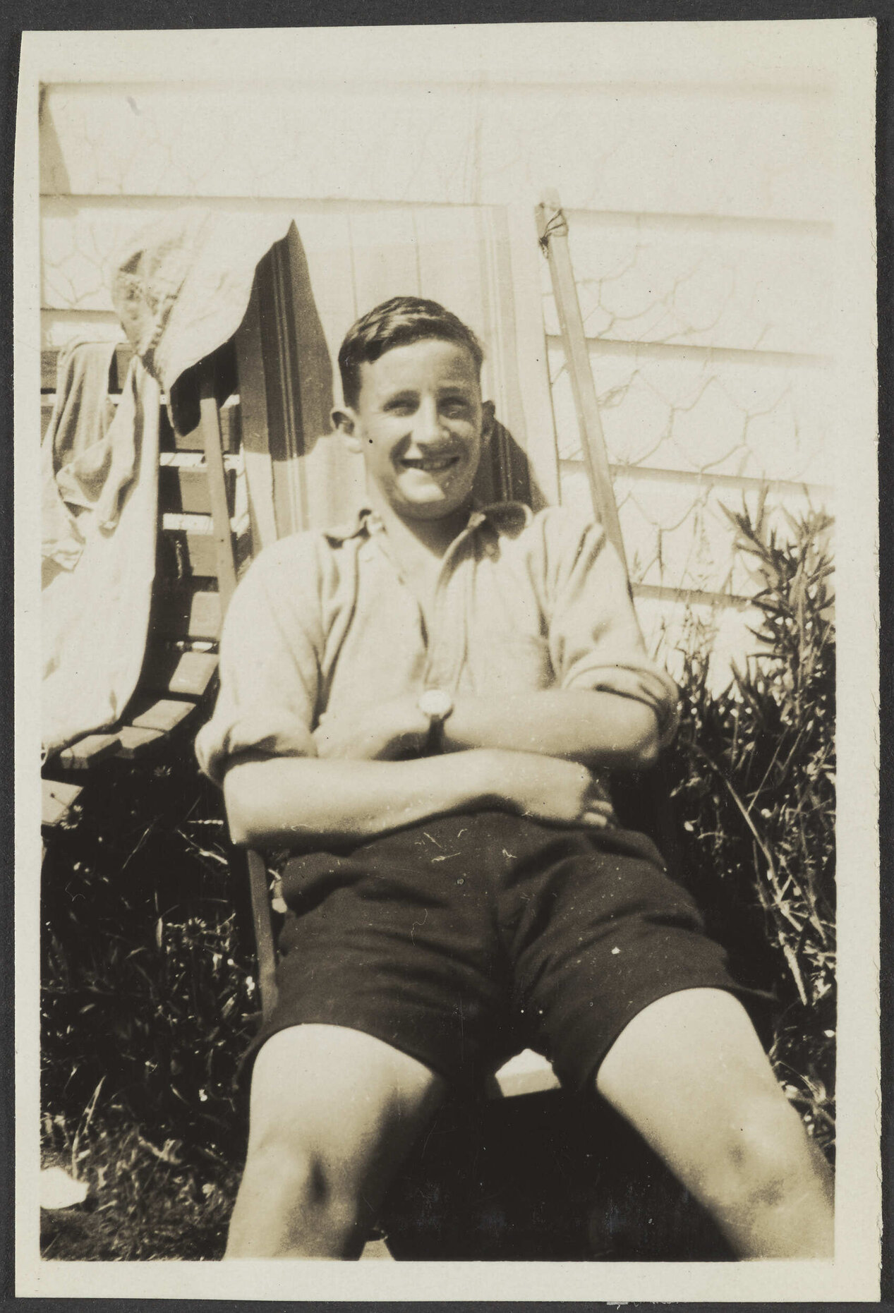 Unidentified man sitting outside wooden house
