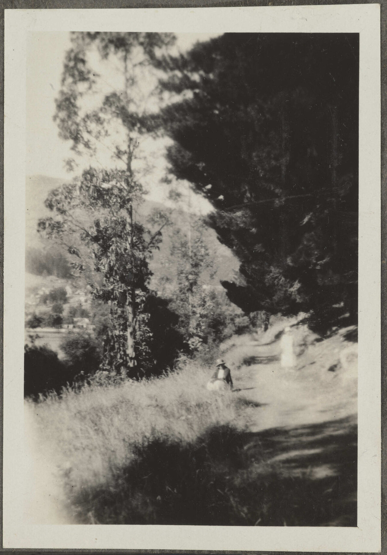 Unidentified woman sitting by path