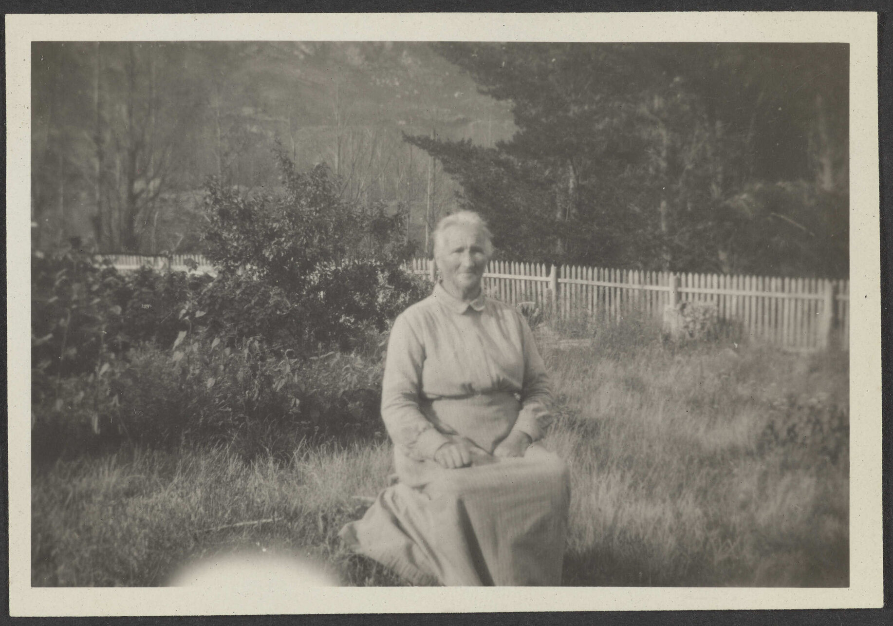 Unidentified woman sitting in grass field