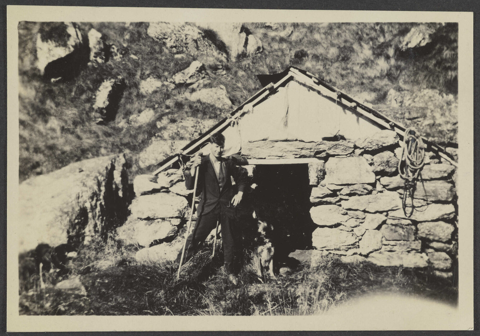 Man standing in front of stone hut