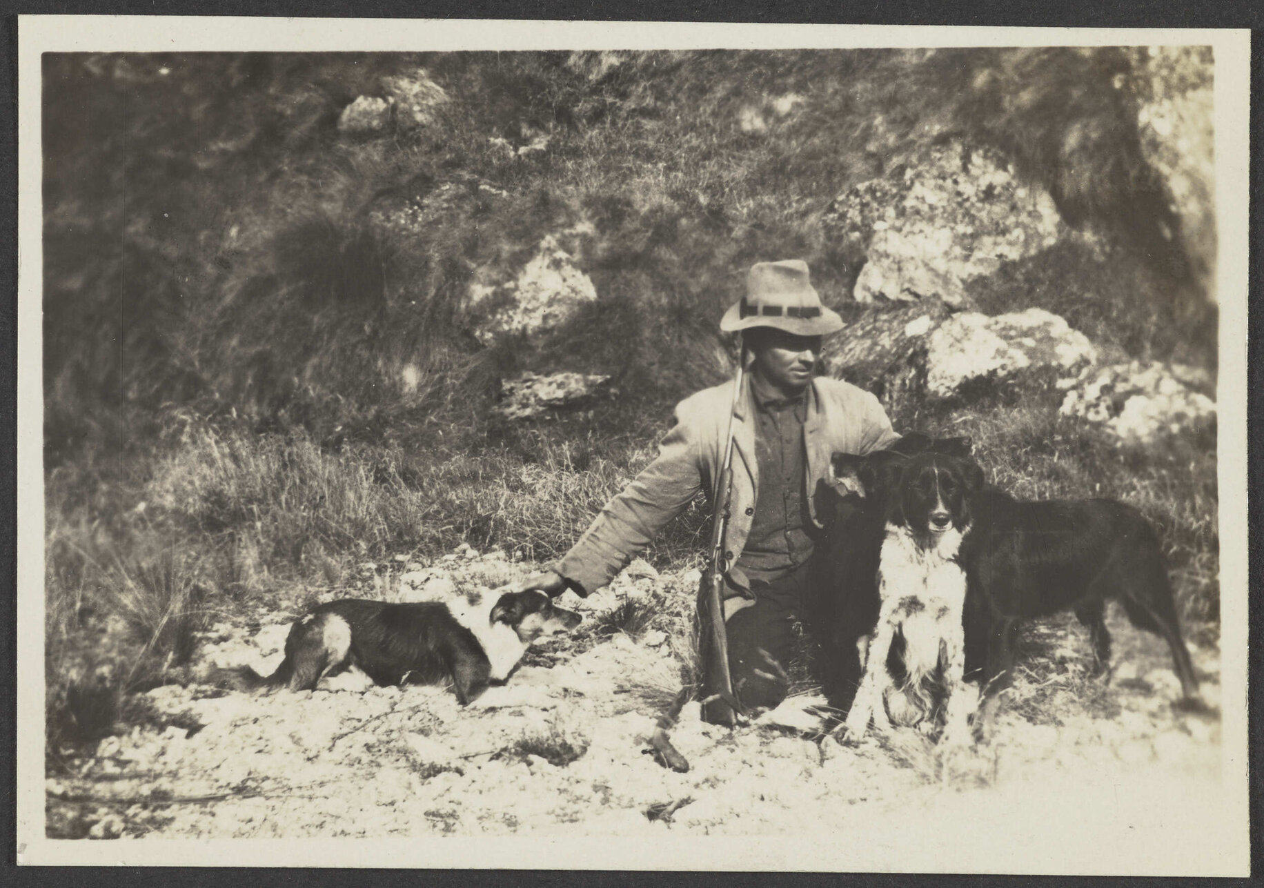 Unidentified man with a gun and two dogs