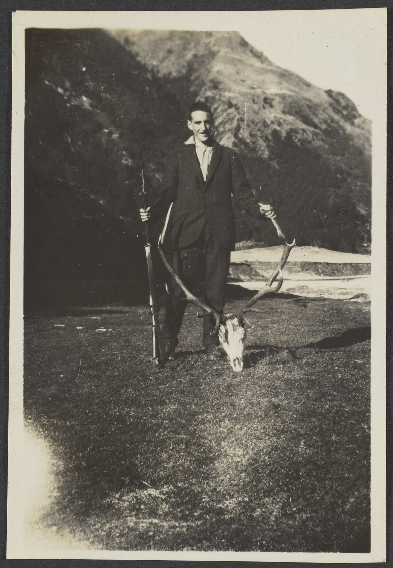 Unidentified man with deer antlers and gun