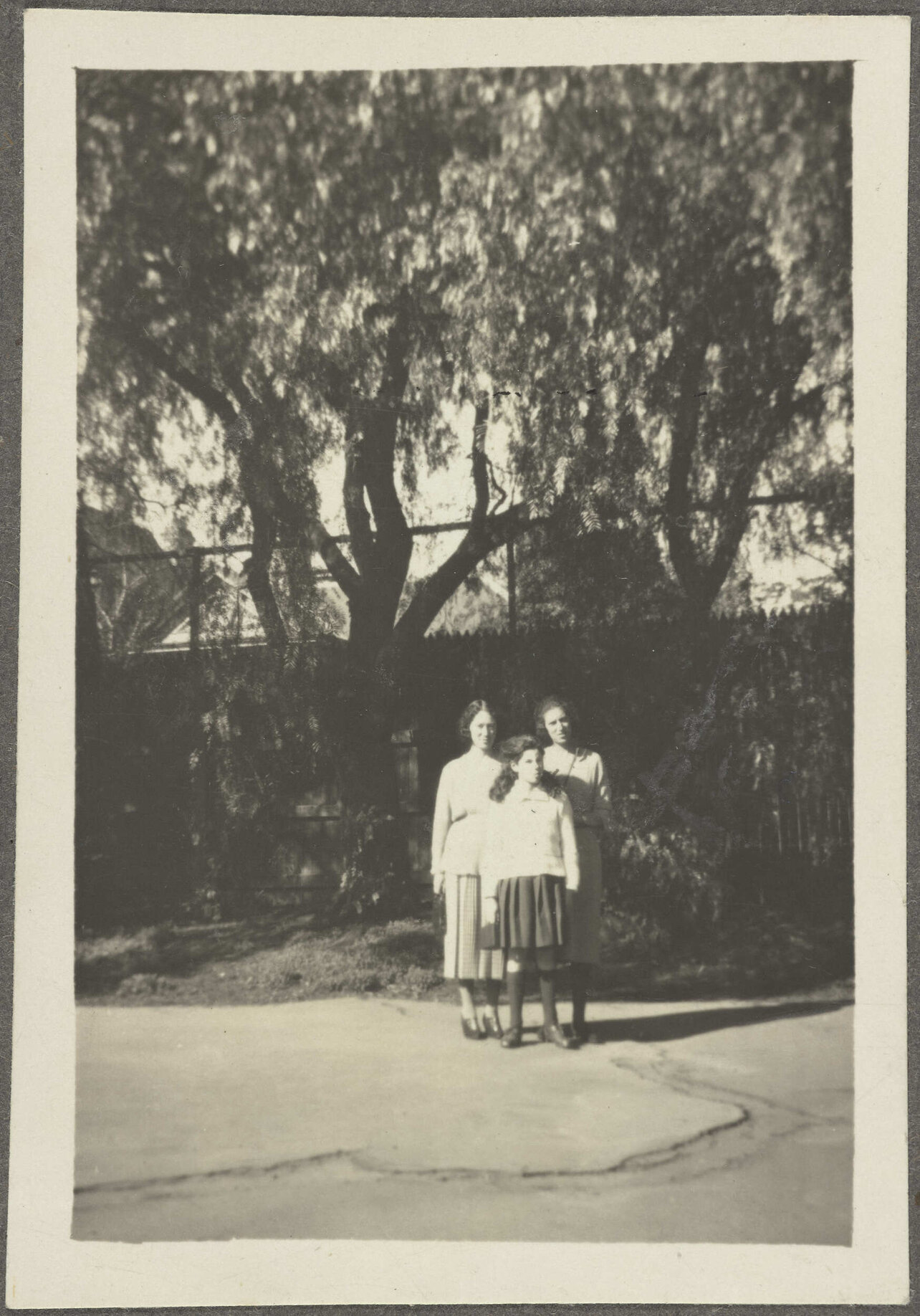 Two unidentified women and Lesley Brasch on pavement