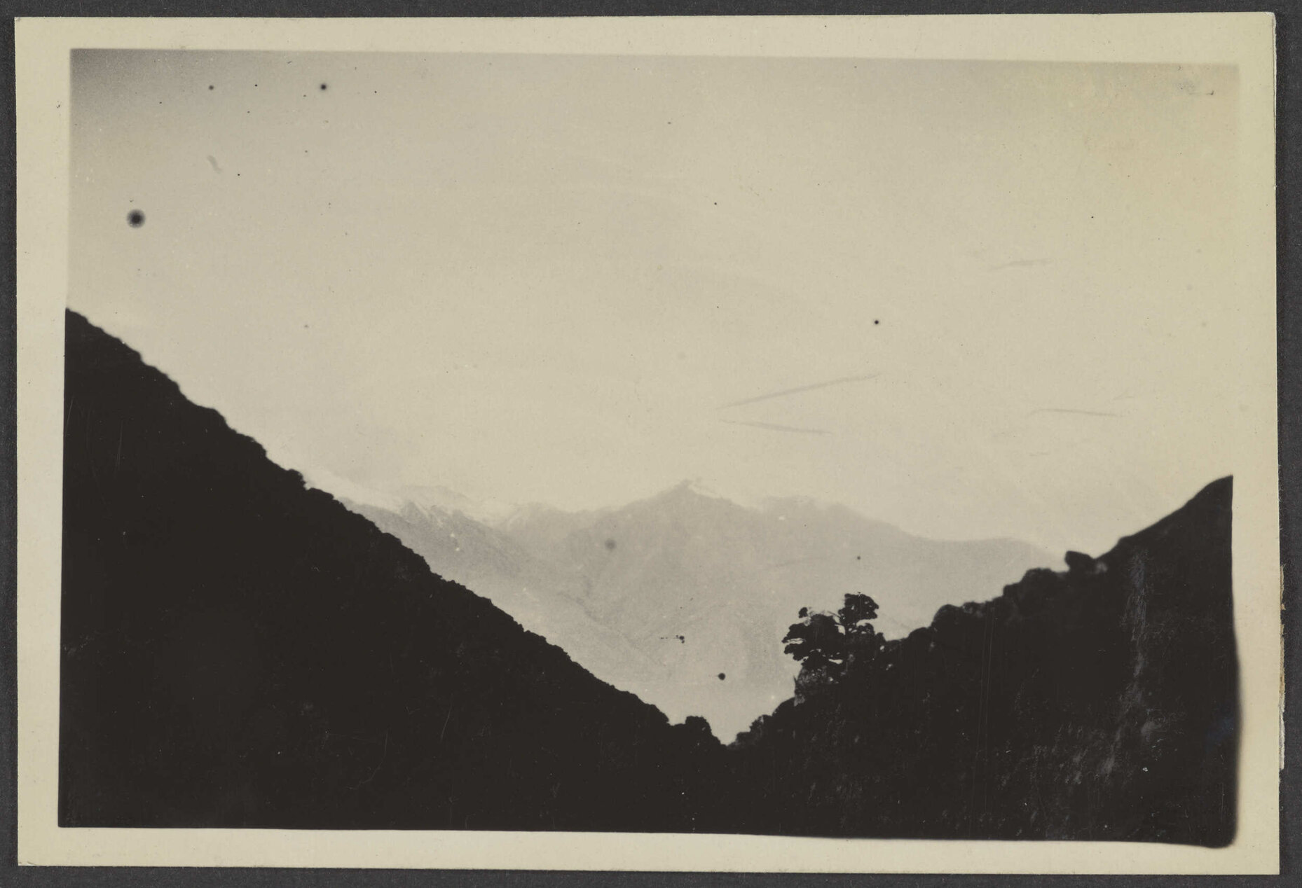 Snow capped mountains through two large hills