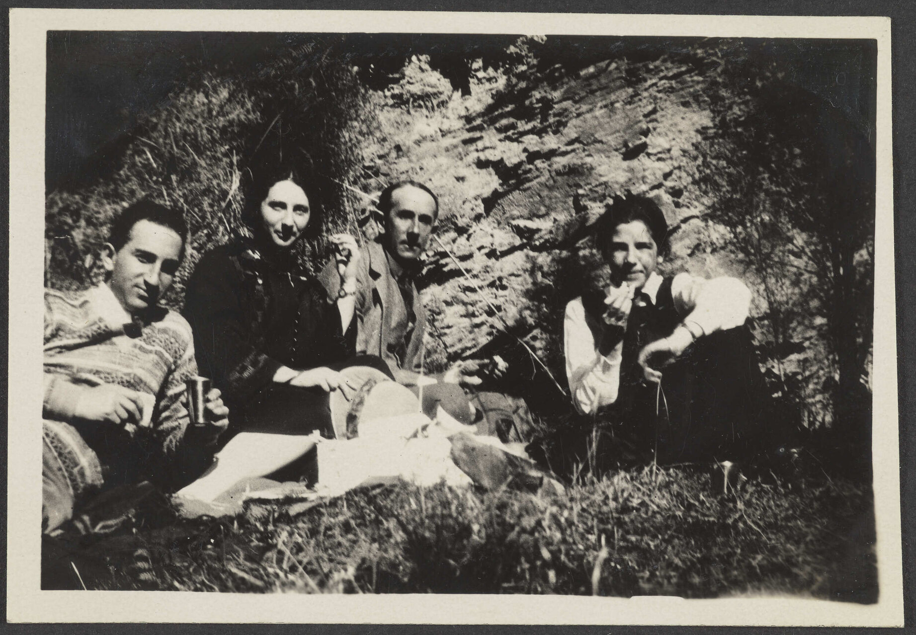 Lesley Brasch and three unidentified people next to rock cliff