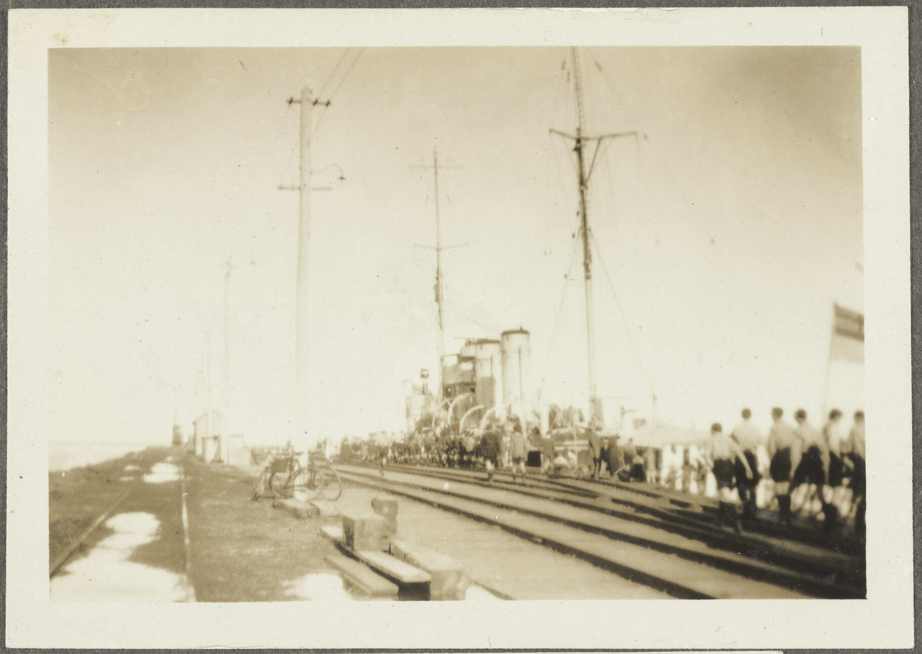 Boys by train tracks heading towards docked ship