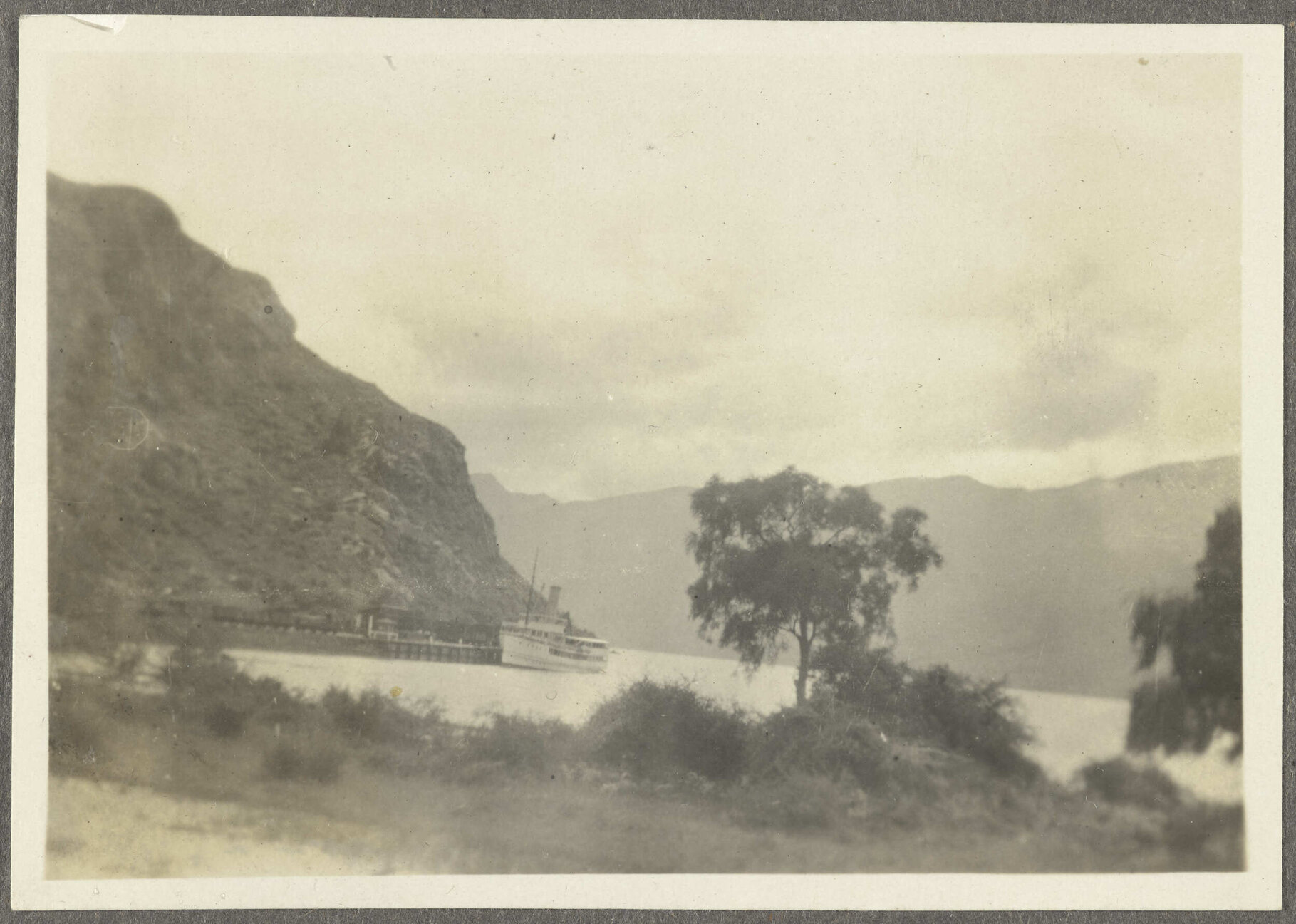 Ship docked at wharf among mountains
