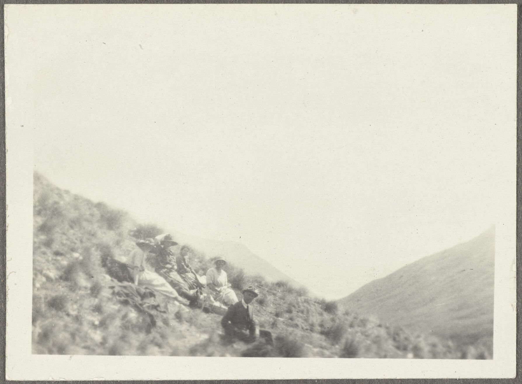 Five people sitting on grass bank