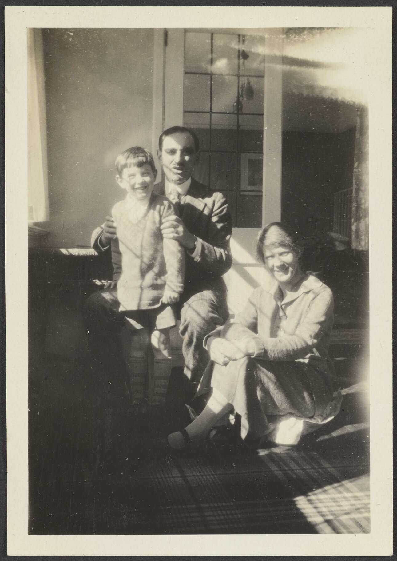 Unidentified boy standing next to an unidentified man and woman