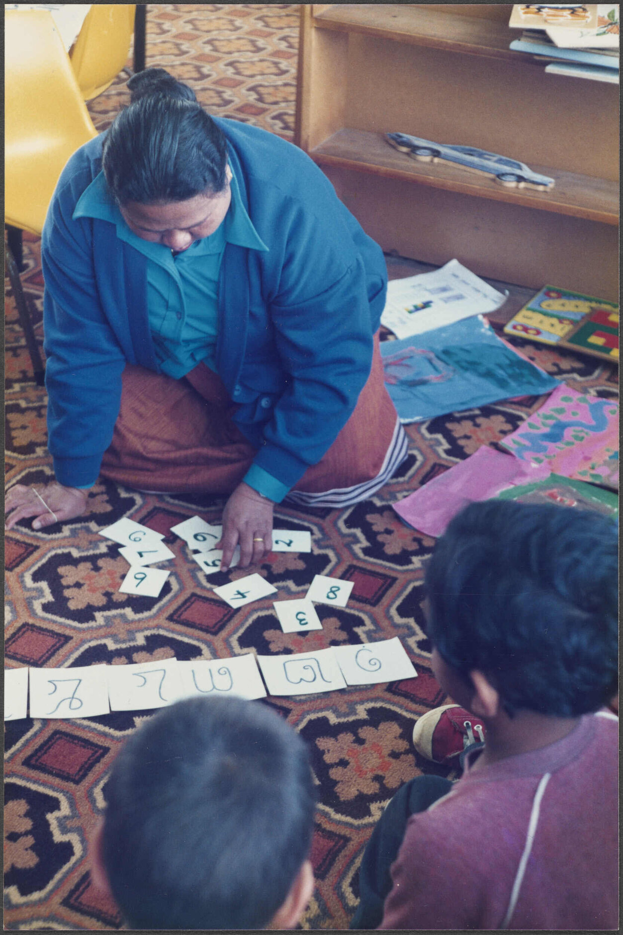Cambodian parent teaching Khmer numbers to children at Arthur Street School