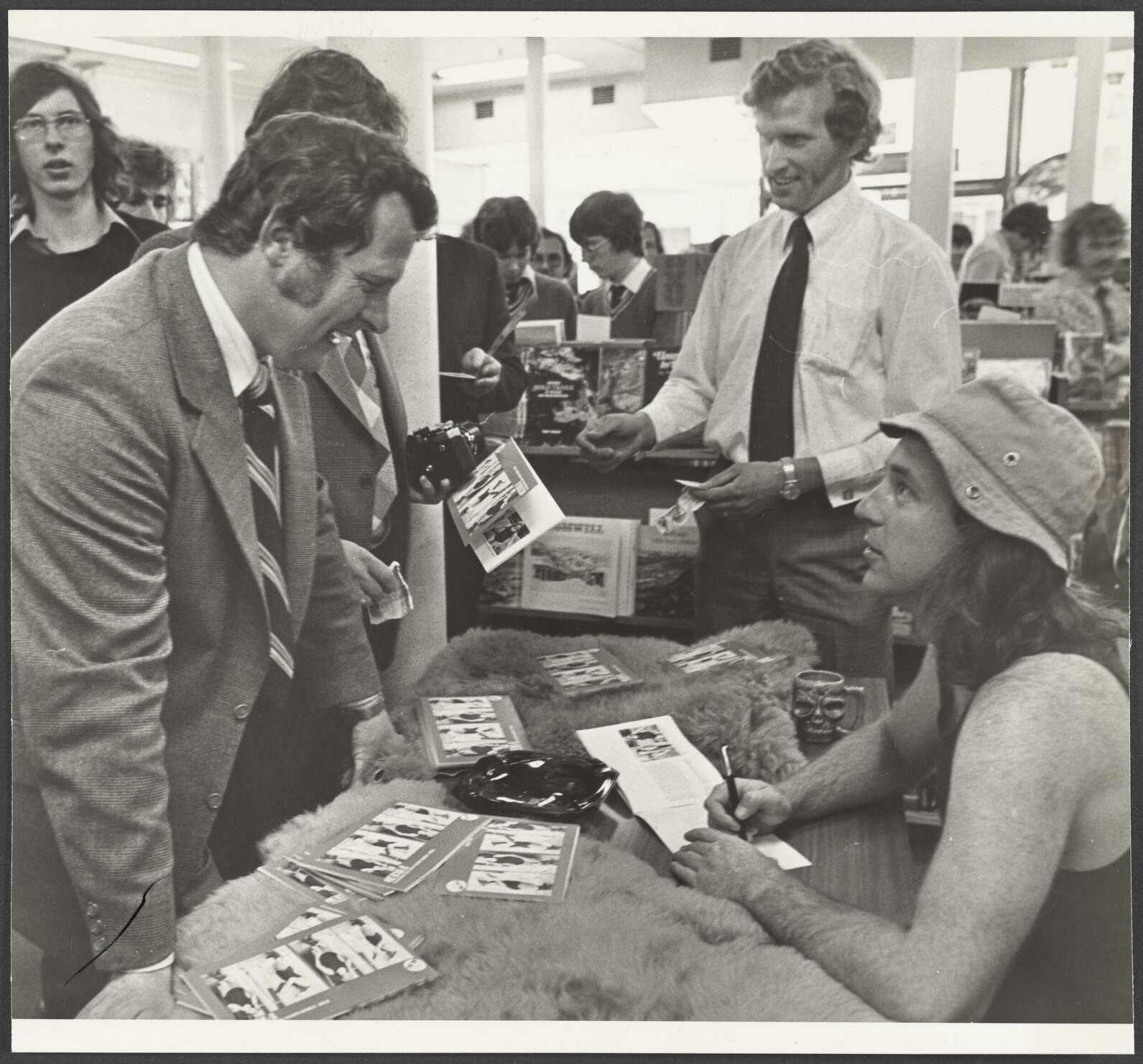 John Clarke as Fred Dagg autographing his book, The Thoughts of Chairman Fred