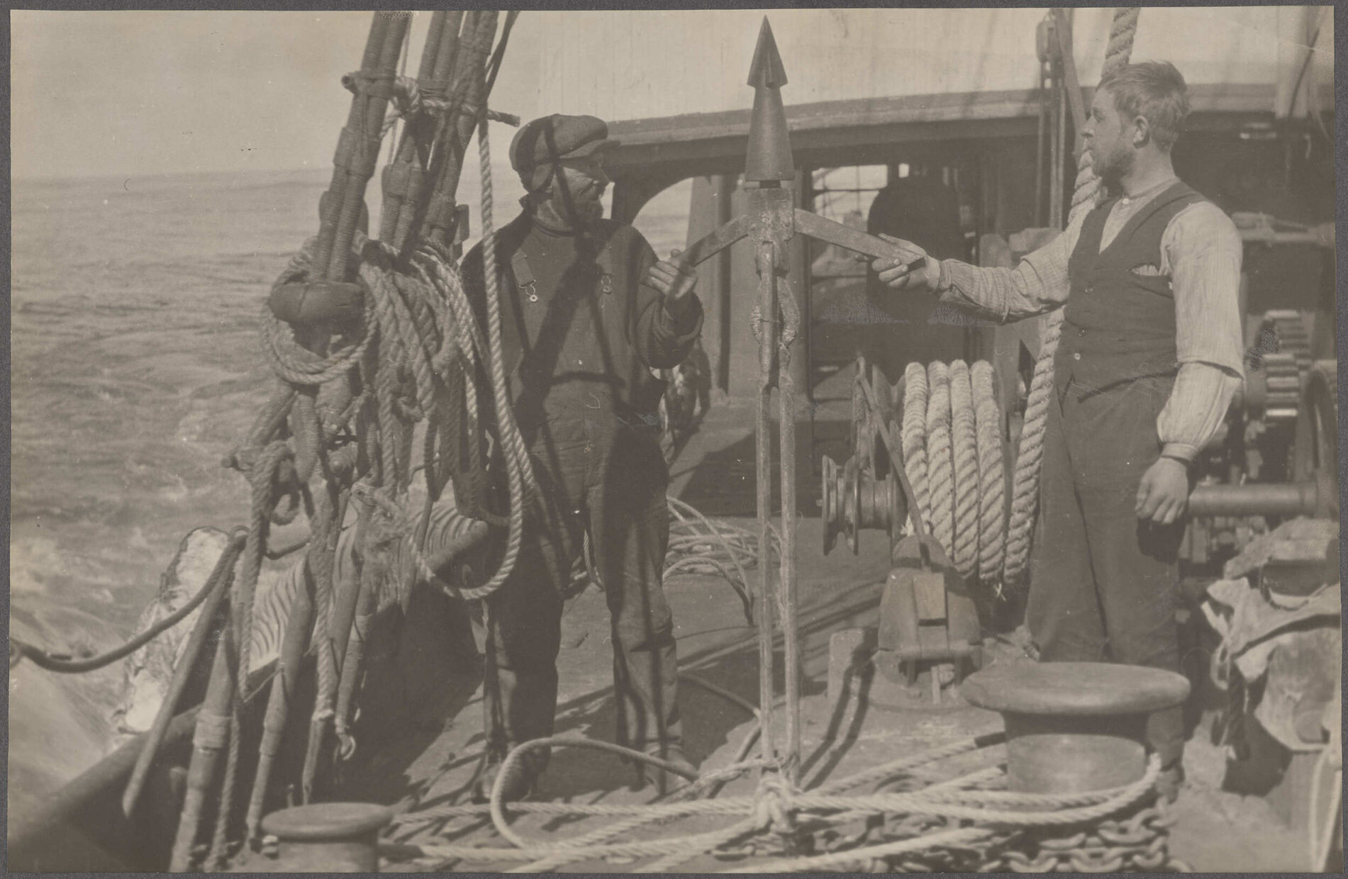 Two crew members holding a harpoon