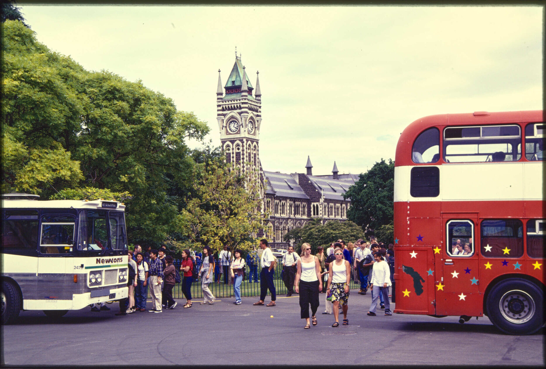 Tour buses at the University of Otago, with clocktower in background