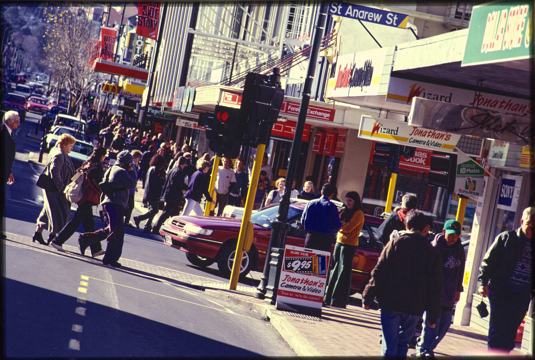 George Street, Dunedin, with pedestrians, vehicle traffic, and shops