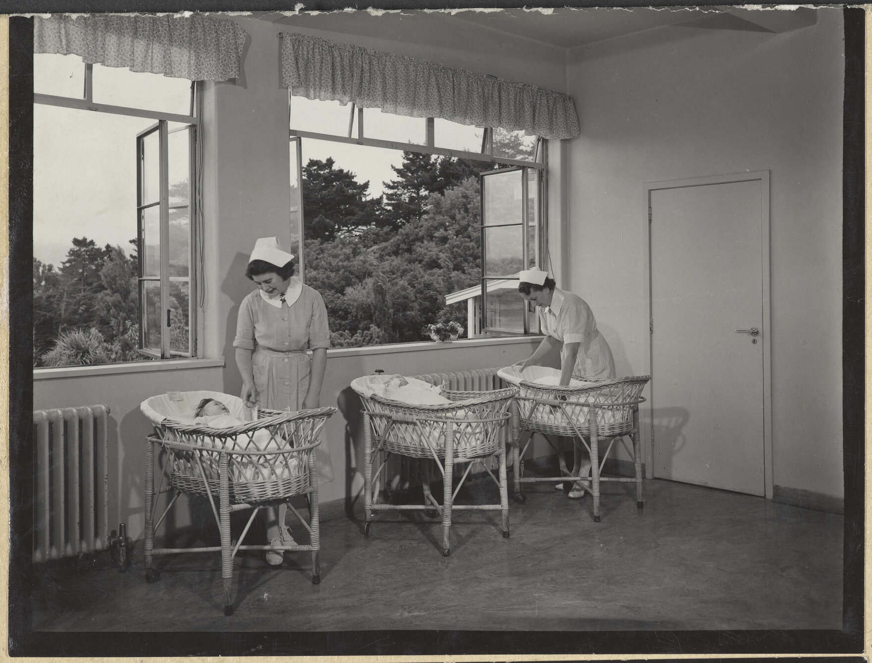 Nurses with babies in bassinets