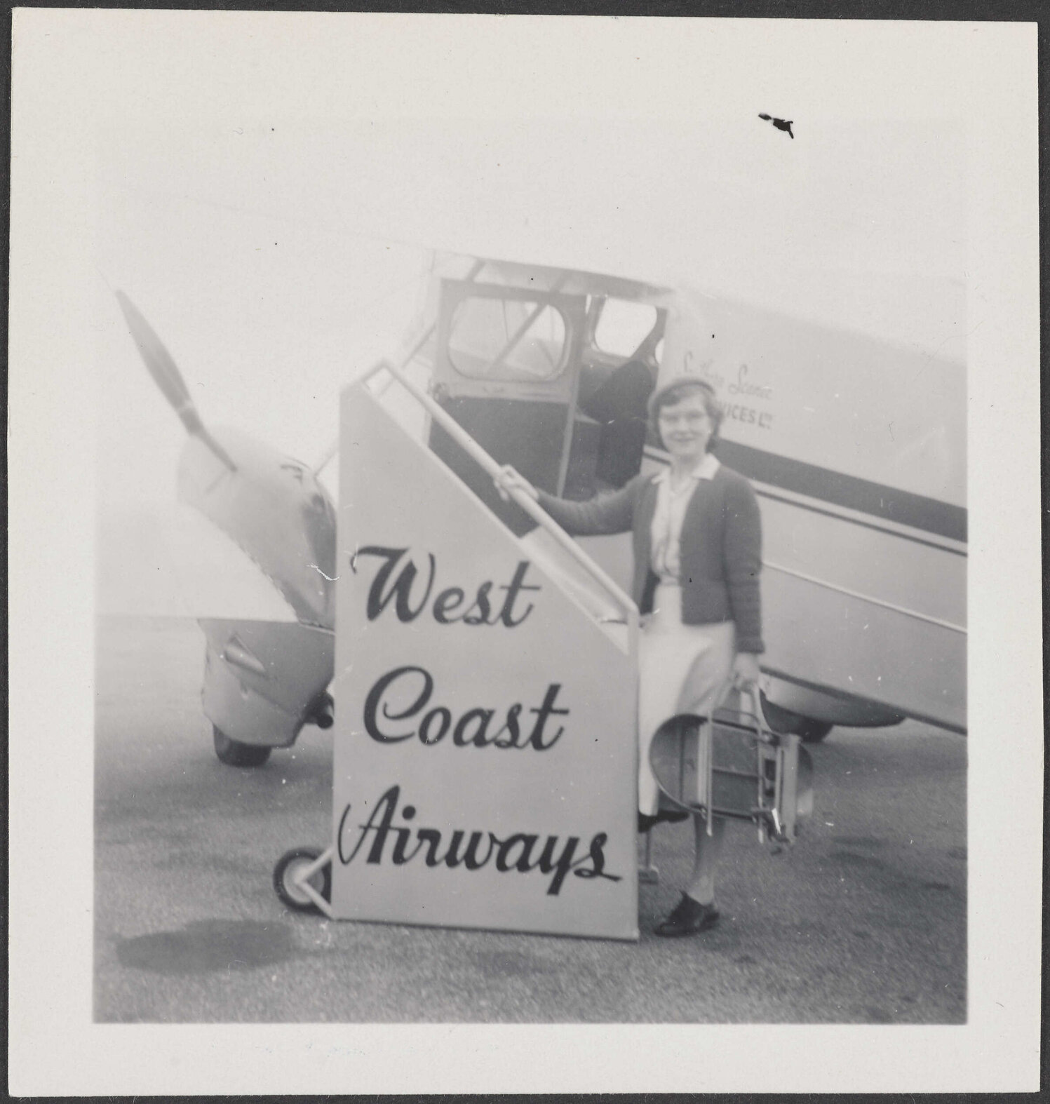 Woman standing in front of a West Coast Airways plane