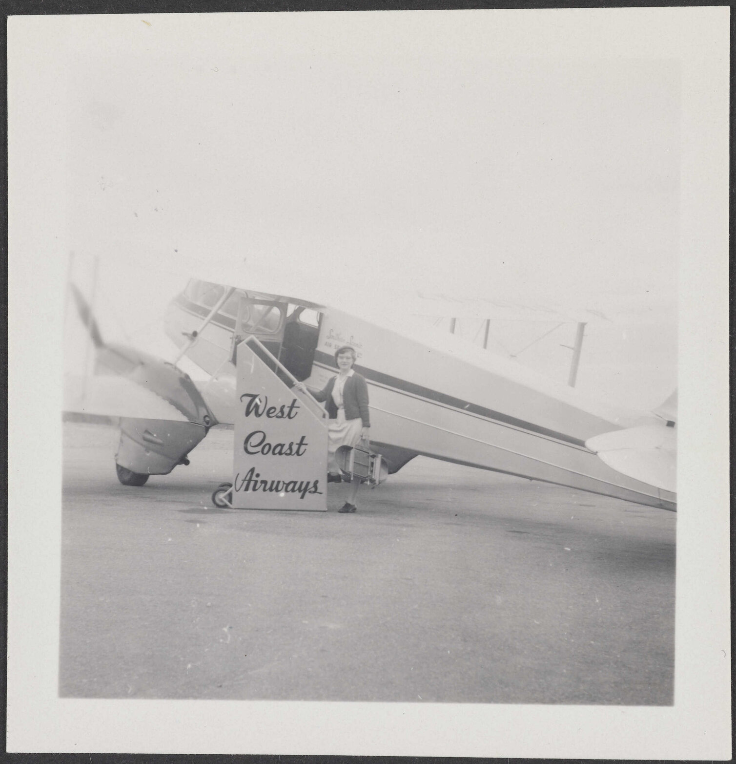 Woman standing in front of a West Coast Airways plane