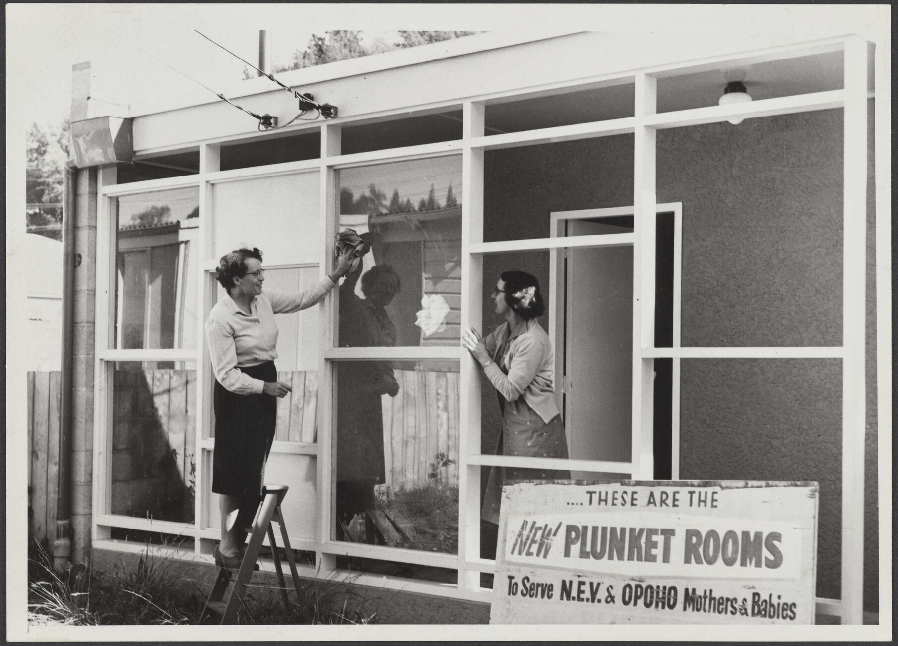 Mrs H. J. Ryburn and another woman cleaning the windows at the North East Valley Plunket Rooms
