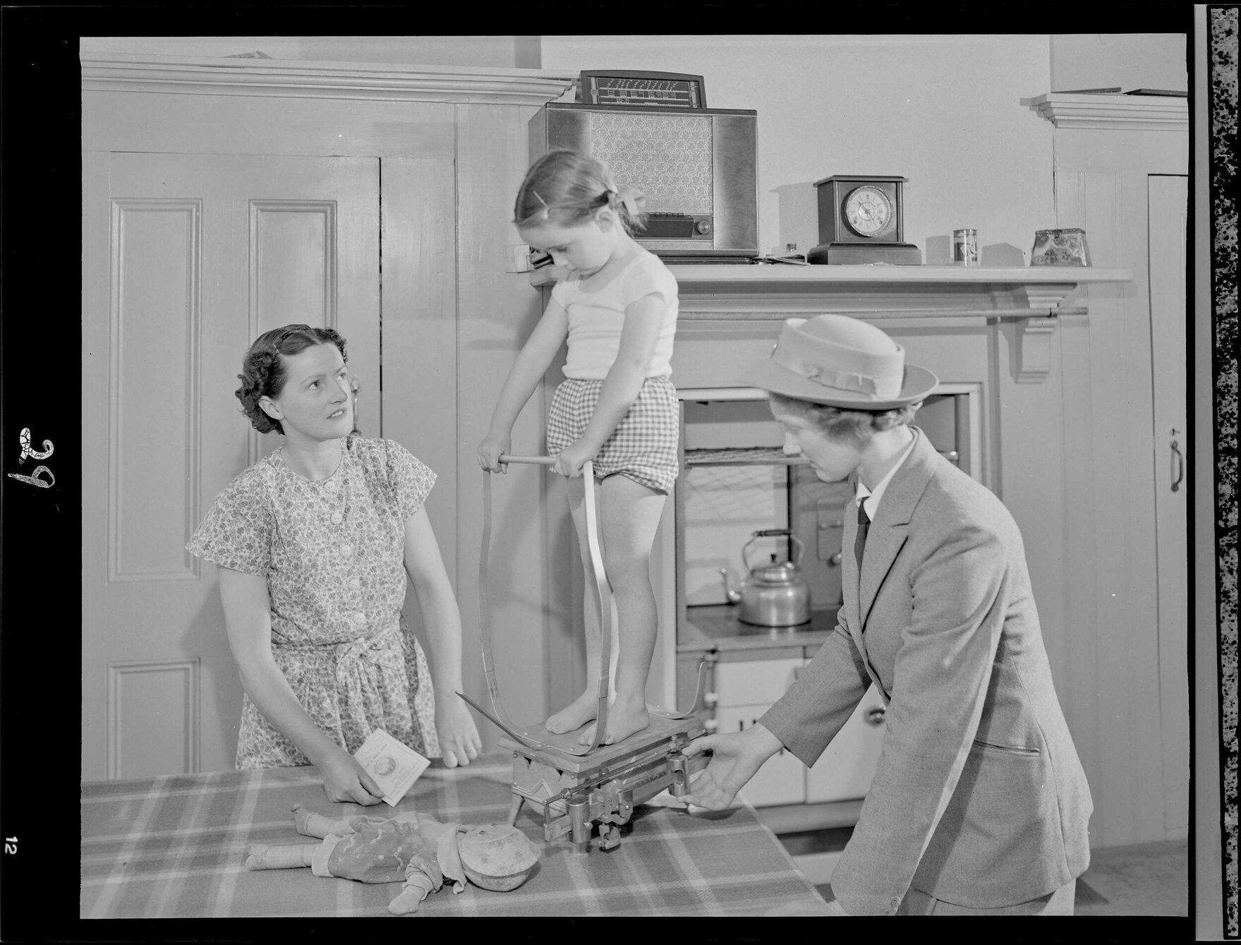 A nurse 'Weighing the Pre School child in the home'