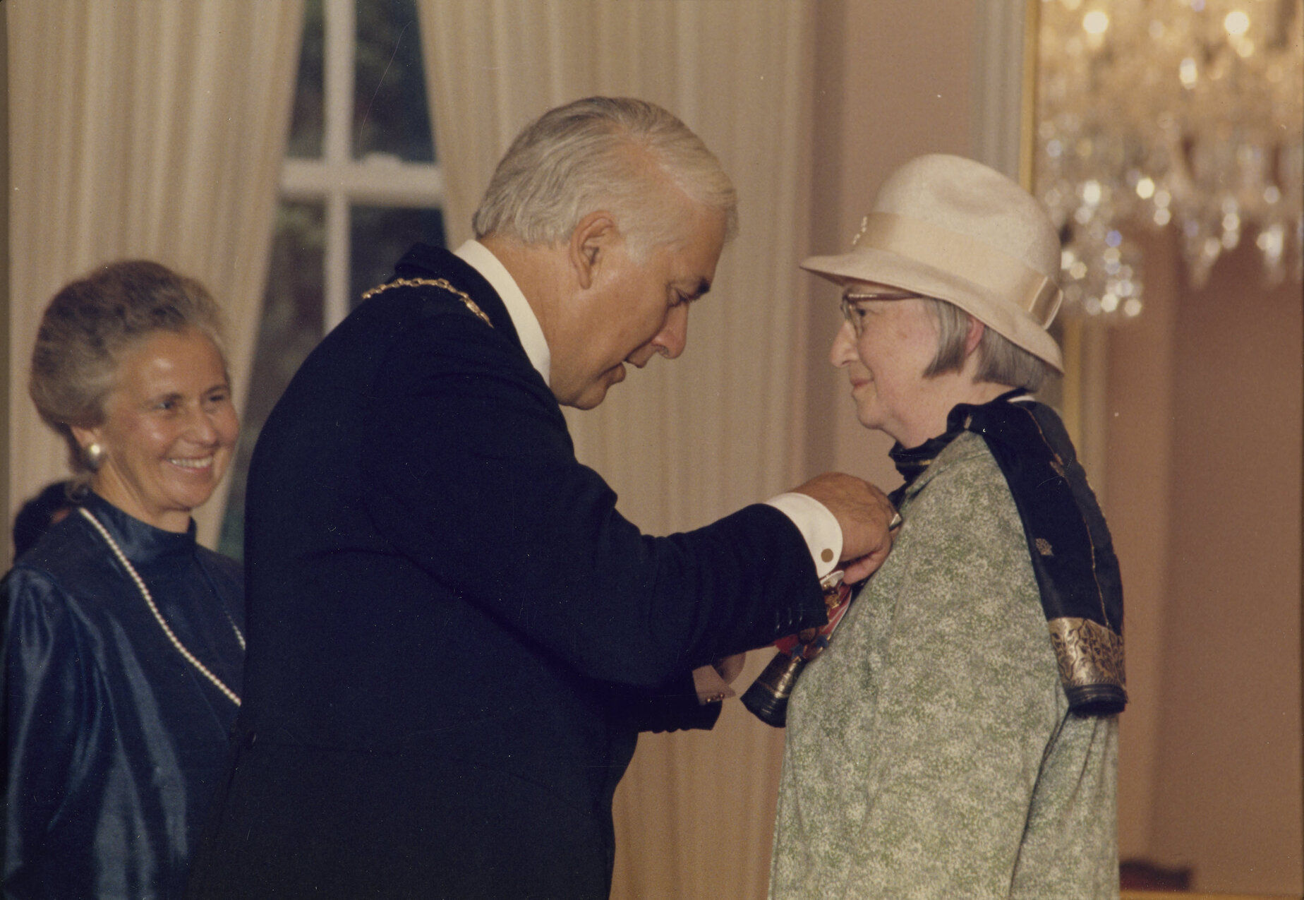 Sir Paul Reeves presenting Dallas with her CBE medal, Lady Reeves in background