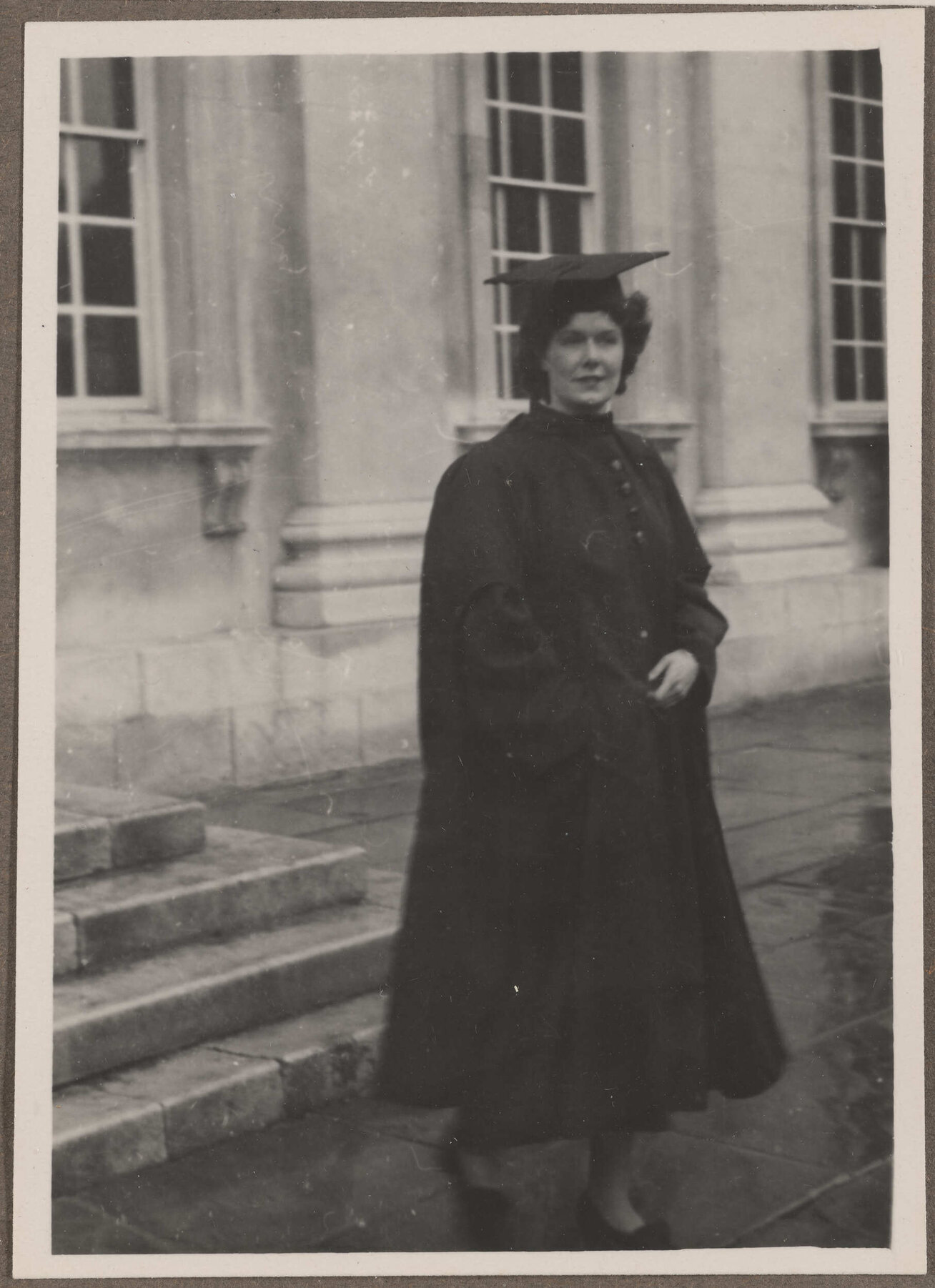 Brenda Slade dressed in academic regalia outside the Senate House, Cambridge