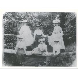 Taken on a bridge at Woodhaugh. Nell Ross of Ravensbourne in centre reclining on bridge. Others not known'