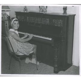 MARIA CHRISTAFSKI, aged 8, at the 100-year old piano in its new home  at Courtney St, Motueka
