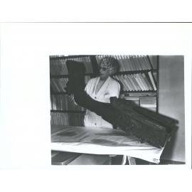 Miss M. Molineux, of the staff of the Dominion Museum, Wgtn, with an ancient Maori Canoe Prow found recently in a plantation at