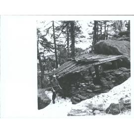 "Sir Edmund Hillary standing outside a shelter created on the rock face, during the climb up to the final camp"