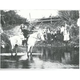 On their way to school: children fording the river, Waikawa Valley