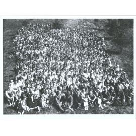 A large group of people sitting in the grass