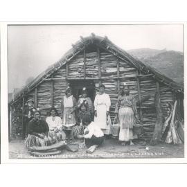 At home, Parihaka, woman scraping potatoes with shell