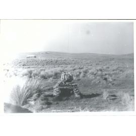 Fireplace with old hut in background