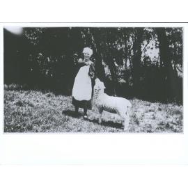 Unidentified woman feeding a sheep from a bottle