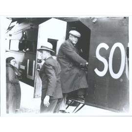 VH-USU, Taieri. Oscar (Balk ?) getting into plane and Wilfred Kingsford-Smith (brother of Charles K.S.). Flight to Oamaru