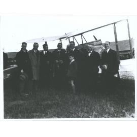 [Group of men and boy in front of plane]