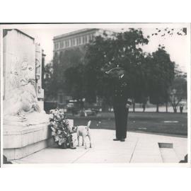 Rear Admiral Byrd saluting at war memorial, Queens Gardens with his dog Igloo