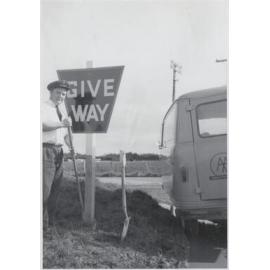 AA patrol officer Erikson with tools, give way sign, and van