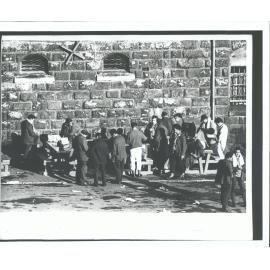 Prisoners sort through clothing & food in the yard