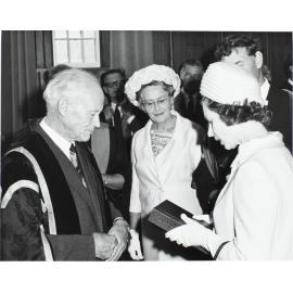 '[University of Otago] Chancellor H.J. Ryburn presenting [Queen Elizabeth II] a copy of the centennial history and centennial record'