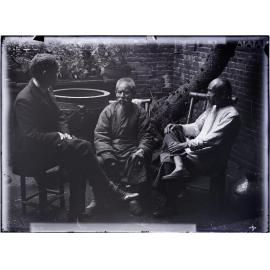 Rev. Mawson [?] and two Chinese men in back courtyard