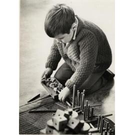 Child playing with wooden pegs
