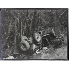 Wrecked motor car at accident site, next to trees and a waterway